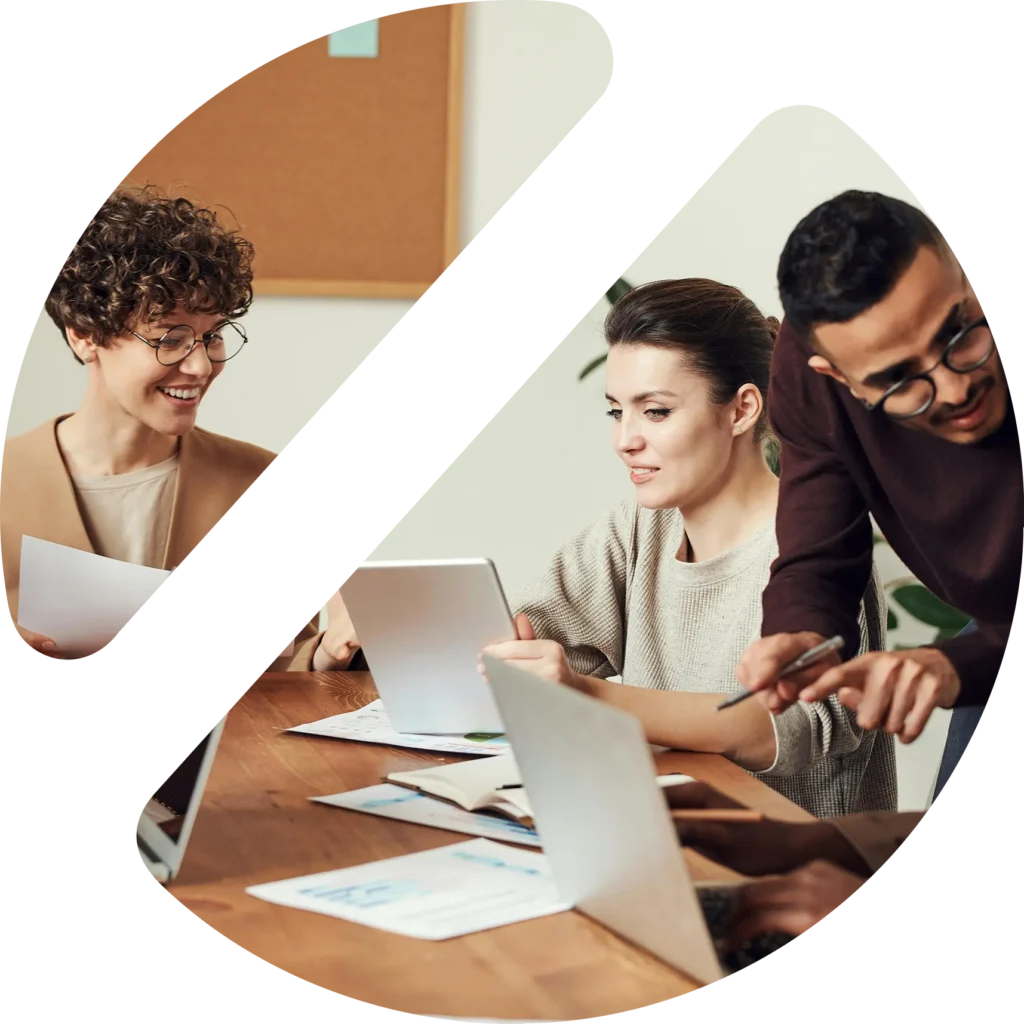 Drei Personen besprechen gemeinsam Inhalte an einem Laptop